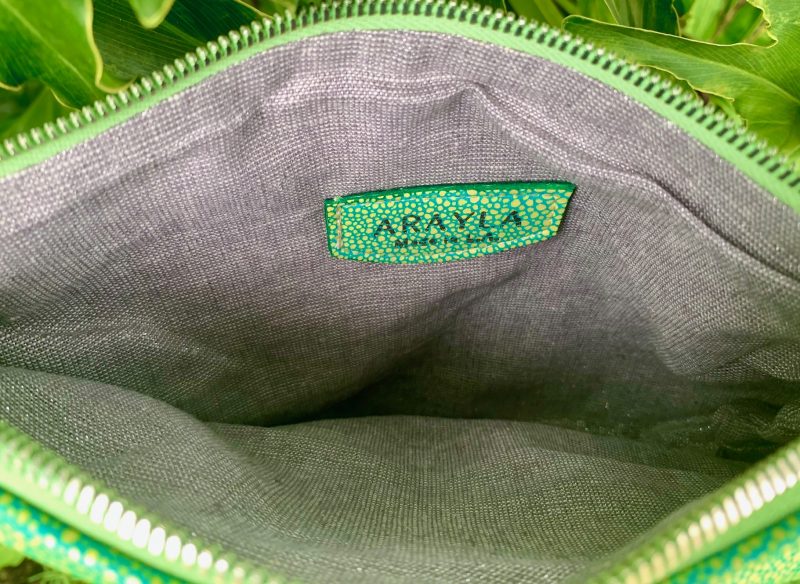 Close-up of the mermaid green stingray embossed leather interior with a visible brand logo on a Silver grey metallic textile lining.