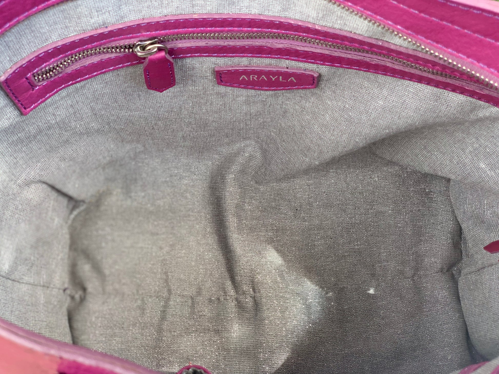 Close-up of theplum purple sheen leather interior with a visible brand logo on a Silver grey metallic textile lining.