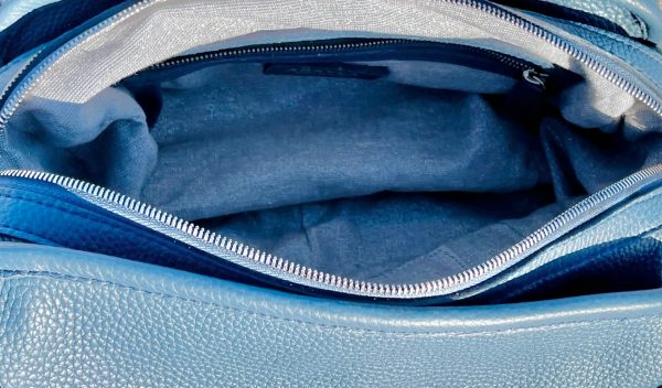 Close-up on the demin blue handbag inside view with a zip pocket.