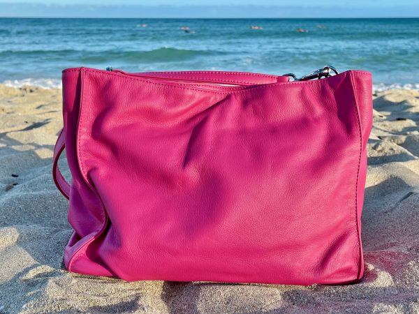 Hibiscus Pink bag back view on a sandy beach with ocean in the background