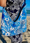 A woman wearing a floral dress holding the cobalt blue leather hobo bag reversed to show the vintage silky fabric lining.