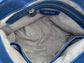 Silver grey metallic textile lining interior of a bag with blue zipper pocket and Arayla brand label.