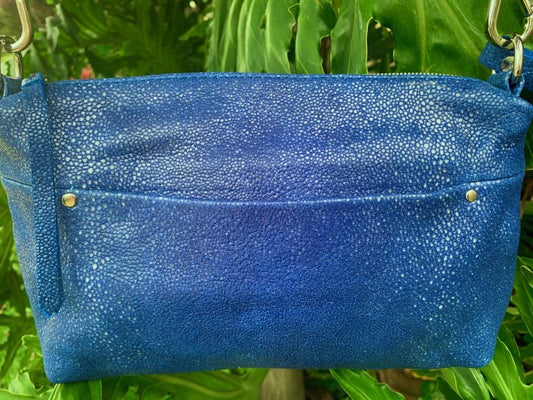 Close-up of  Ehukai Blue Stingray Embossed Leather bag with Front external slip pocket and Wrist strap