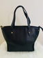 Onyx black leather tote bag back view with gold hardware on a white surface