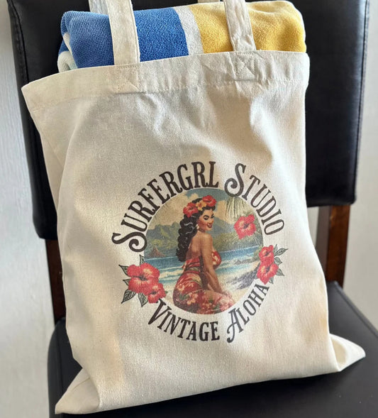 Tote bag with 'Surfergirl Studio Vintage Aloha' design on a chair