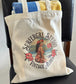 Tote bag with 'Surfergirl Studio Vintage Aloha' design on a chair